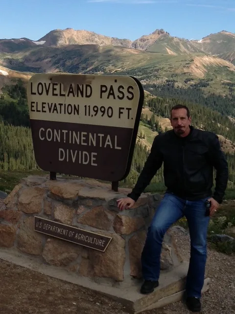 Standing at the Loveland Pass Continental Divide marker, elevation 11,990 ft