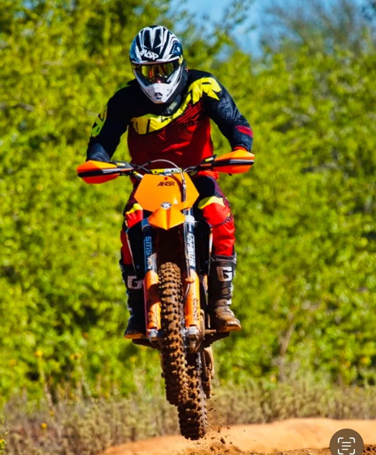 Motocross rider airborne off a dirt jump