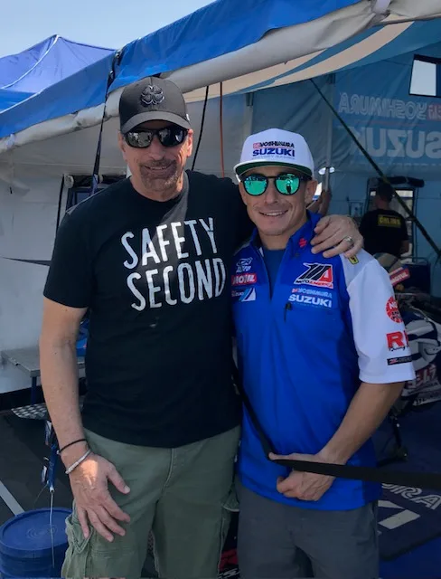 Two riders in the paddock at a Suzuki race tent